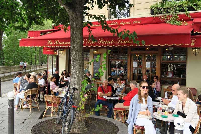 Gezellig terrasje bij Saint-Louis tijdens je wandeling langs de groene boekenkramen in Parijs