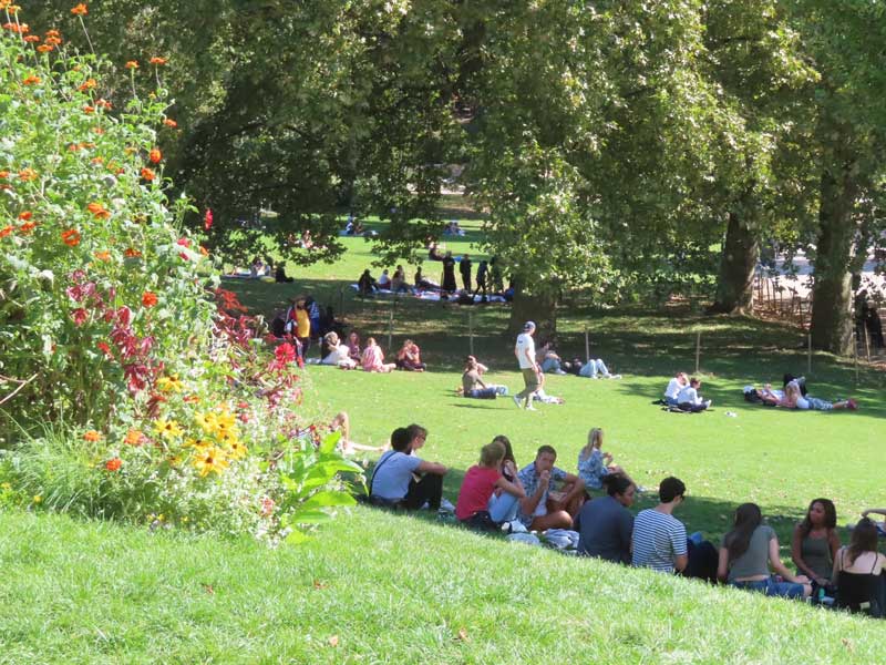 Parijzenaren picknicken en ontspannen graag op het gras van Parc des Buttes-Chaumont